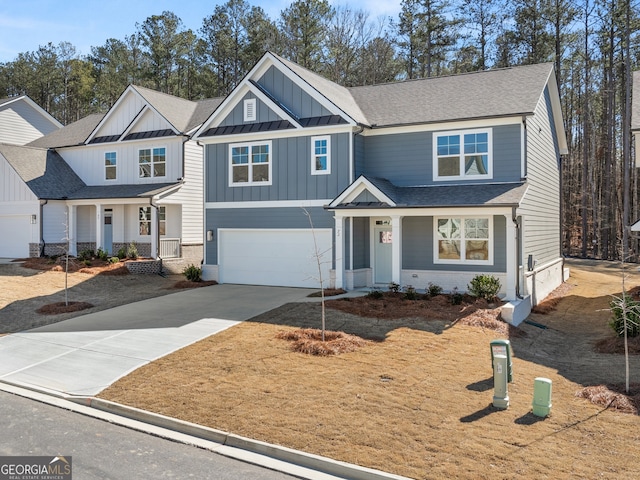 view of front of house with a shingled roof, an attached garage, board and batten siding, a standing seam roof, and driveway