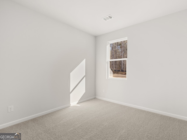 unfurnished room featuring light carpet, visible vents, and baseboards