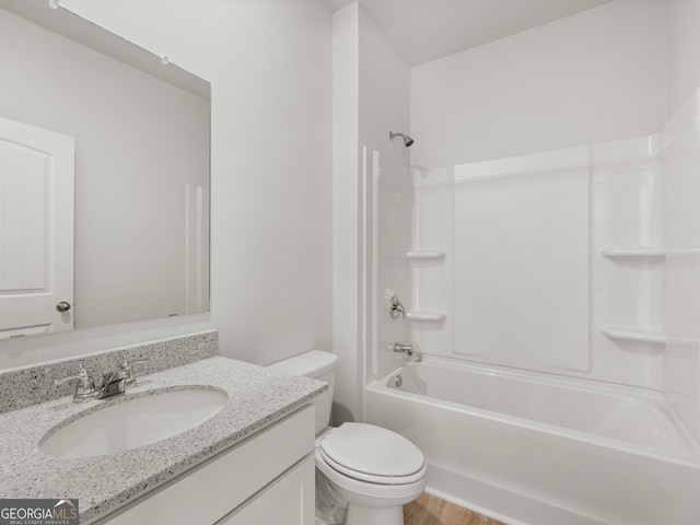 bathroom with washtub / shower combination, wood finished floors, vanity, and toilet