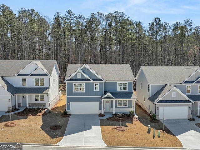 traditional home with board and batten siding, a shingled roof, a garage, and concrete driveway