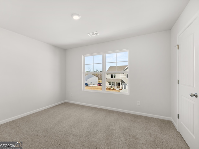 carpeted empty room featuring visible vents and baseboards