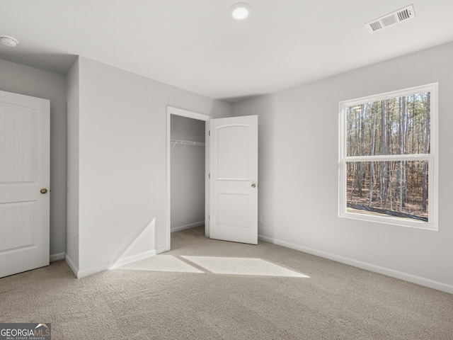 unfurnished bedroom with a closet, carpet, visible vents, and baseboards