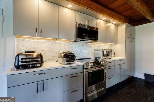 kitchen with appliances with stainless steel finishes, backsplash, gray cabinets, and beam ceiling