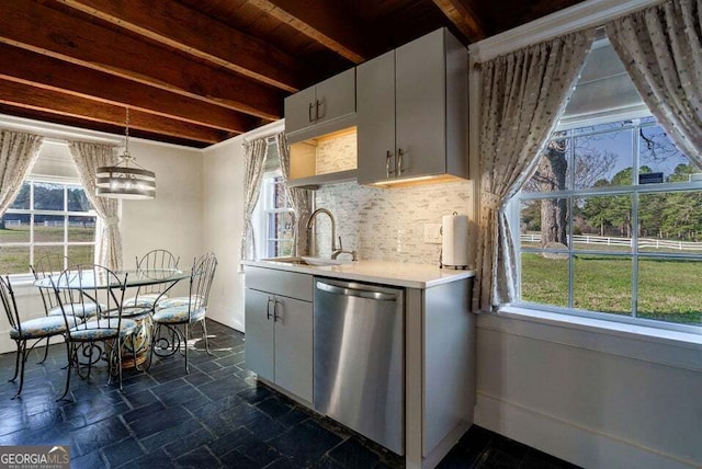 kitchen featuring stone tile flooring, backsplash, stainless steel dishwasher, a sink, and beamed ceiling