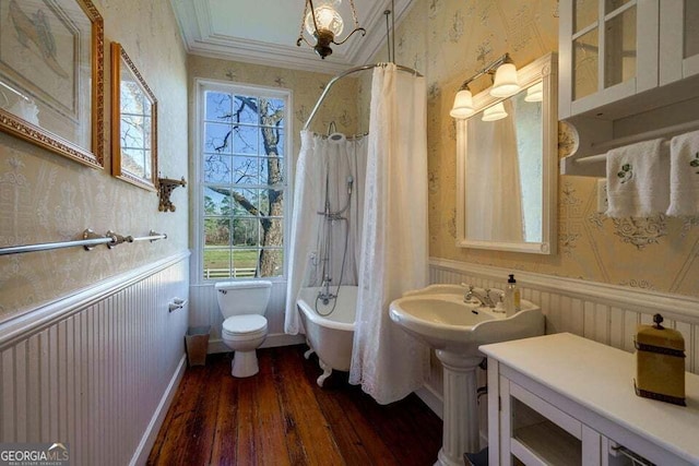 full bathroom featuring a wainscoted wall, toilet, shower / bath combo, wood finished floors, and wallpapered walls