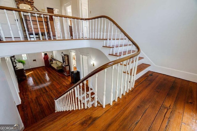 stairway with wood-type flooring and baseboards