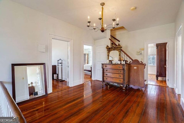 interior space with an inviting chandelier, vaulted ceiling, and hardwood / wood-style floors