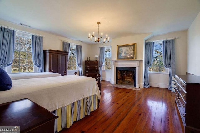 bedroom featuring hardwood / wood-style floors, multiple windows, a fireplace with flush hearth, and baseboards