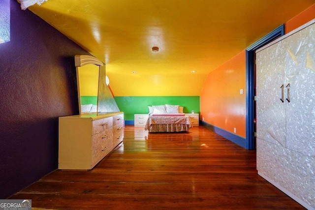 bedroom featuring wood-type flooring and vaulted ceiling