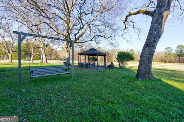 view of property's community featuring a yard, fence, and a gazebo