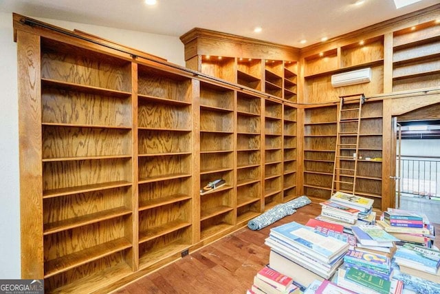 wine room featuring a wall mounted AC, wood finished floors, and recessed lighting