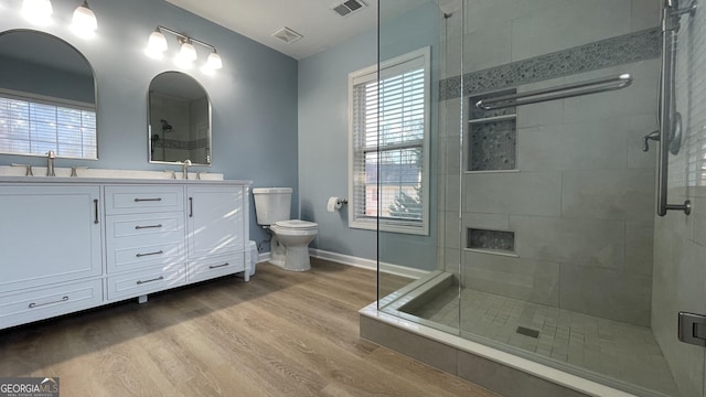 full bathroom with visible vents, a sink, toilet, and wood finished floors