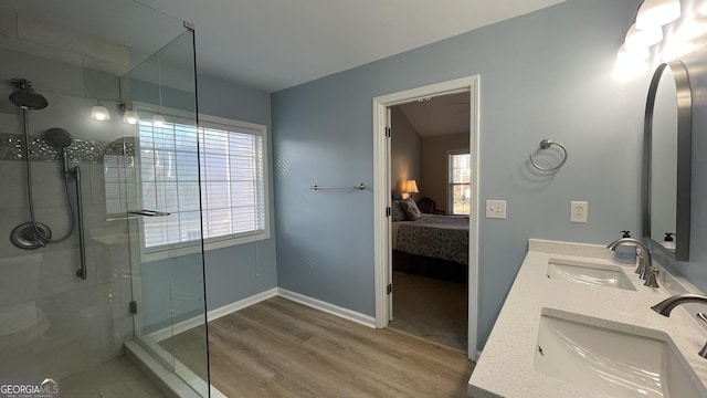 bathroom with ensuite bath, wood finished floors, a stall shower, and a sink