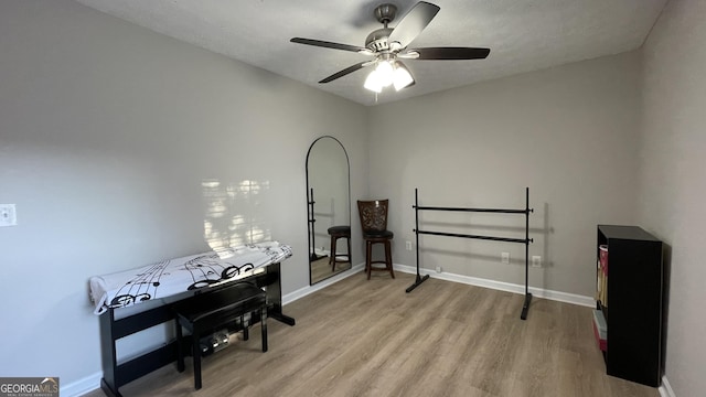 misc room featuring a ceiling fan, baseboards, and wood finished floors