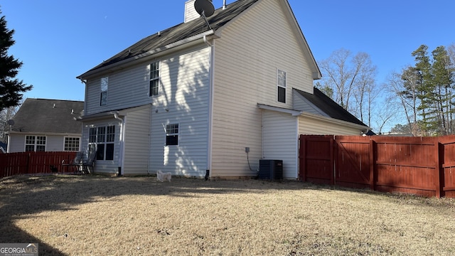 back of house with a yard, central AC unit, a chimney, and fence