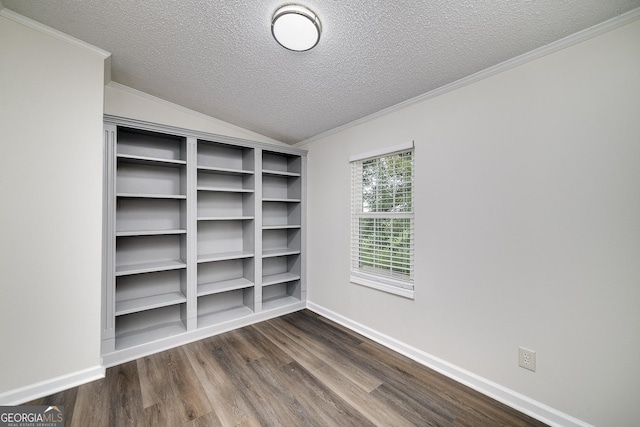 spare room featuring baseboards, dark wood-style flooring, vaulted ceiling, crown molding, and a textured ceiling