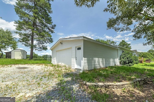 detached garage featuring driveway and a storage unit