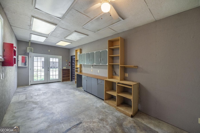 miscellaneous room featuring french doors and unfinished concrete flooring