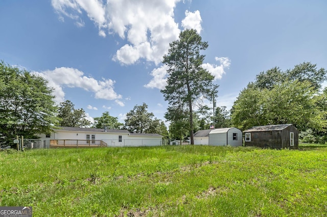 view of yard with a storage shed, a deck, and an outdoor structure