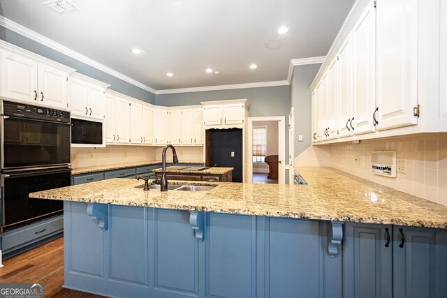 kitchen featuring dobule oven black, visible vents, dark wood finished floors, a peninsula, and a sink