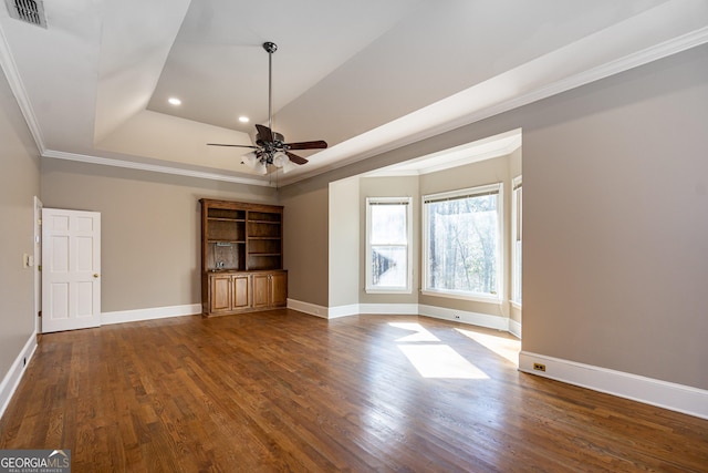 unfurnished living room featuring baseboards, visible vents, ornamental molding, dark wood-style flooring, and a tray ceiling