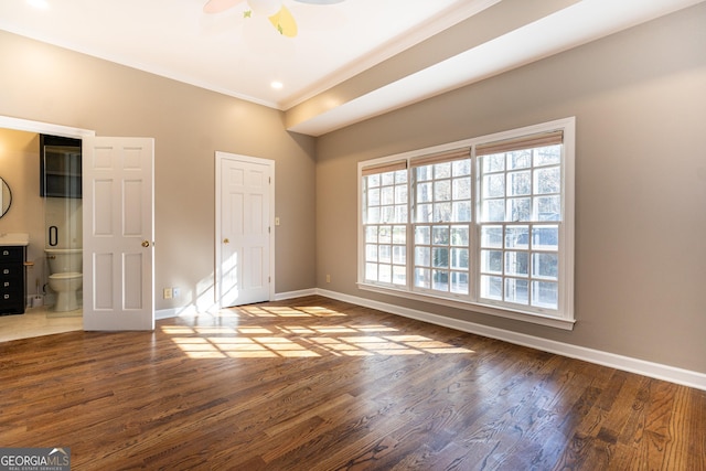 interior space with ensuite bathroom, ornamental molding, wood finished floors, and baseboards