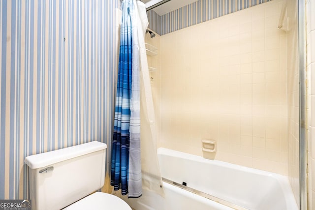 full bathroom with shower / bath combo with shower curtain, toilet, and wallpapered walls