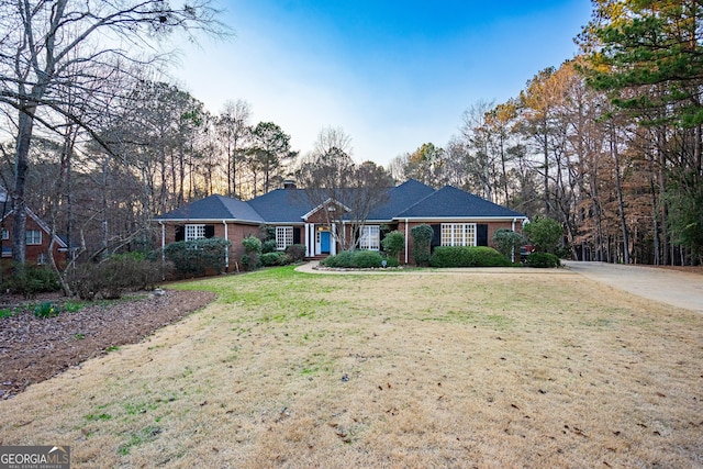 ranch-style house with brick siding and a front yard