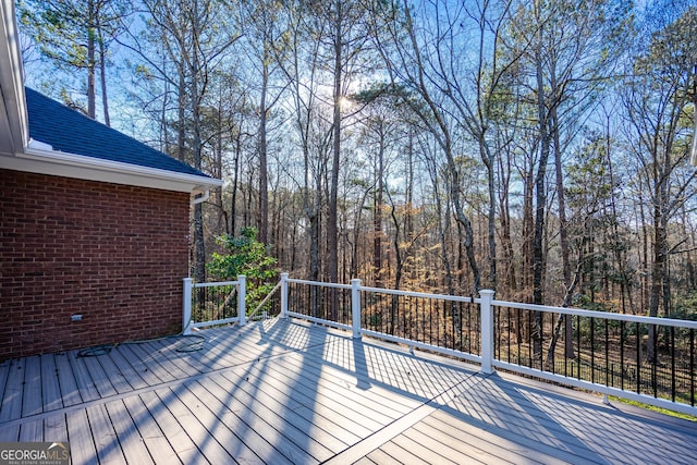 wooden terrace featuring a wooded view