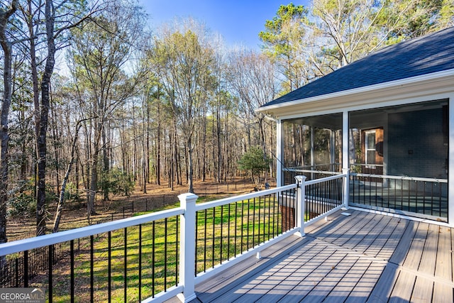 wooden deck with a yard and a sunroom