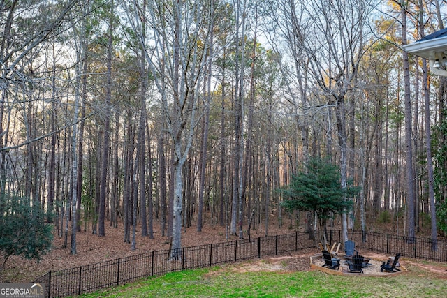 view of yard with an outdoor fire pit and fence