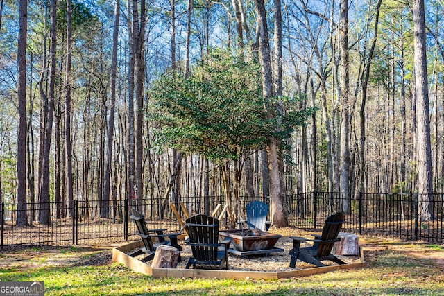 view of yard with an outdoor fire pit and fence