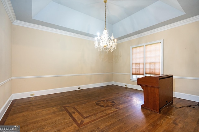 spare room featuring dark wood-type flooring, a tray ceiling, ornamental molding, and baseboards