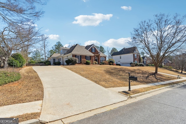 view of front of property featuring a front yard, concrete driveway, and brick siding