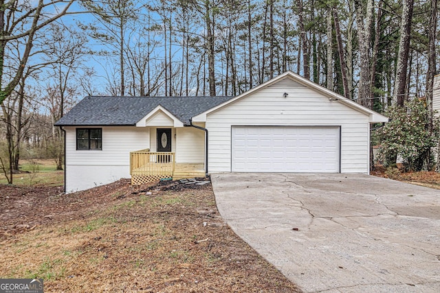 ranch-style house with a garage, a shingled roof, and concrete driveway