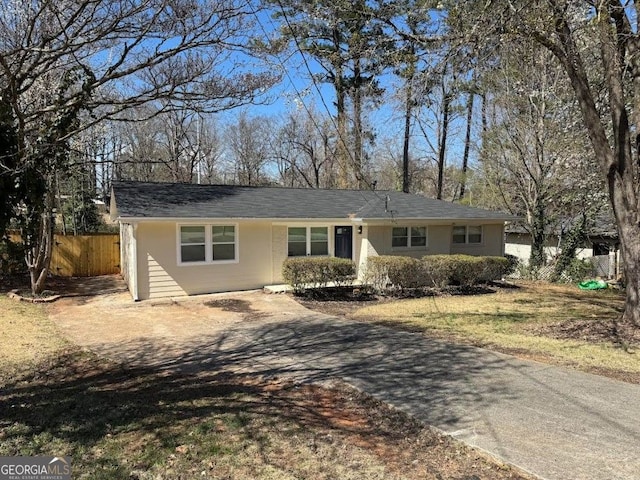 ranch-style home with fence and concrete driveway