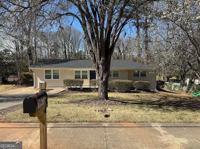 ranch-style house with central AC unit, a front yard, and stucco siding