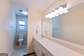bathroom with vanity, toilet, and baseboards