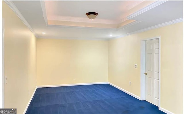 empty room with baseboards, a raised ceiling, and crown molding