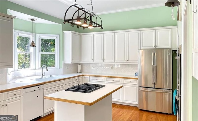 kitchen featuring black gas cooktop, white dishwasher, a sink, white cabinets, and freestanding refrigerator