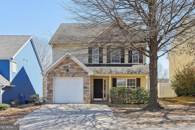 traditional-style house featuring a garage, stone siding, a shingled roof, and concrete driveway