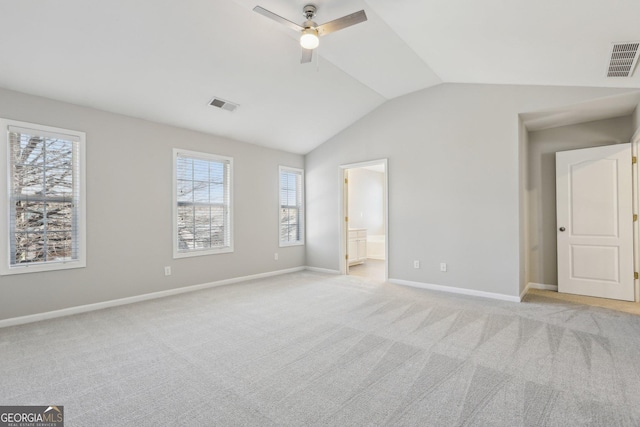 unfurnished bedroom featuring light carpet, vaulted ceiling, visible vents, and baseboards