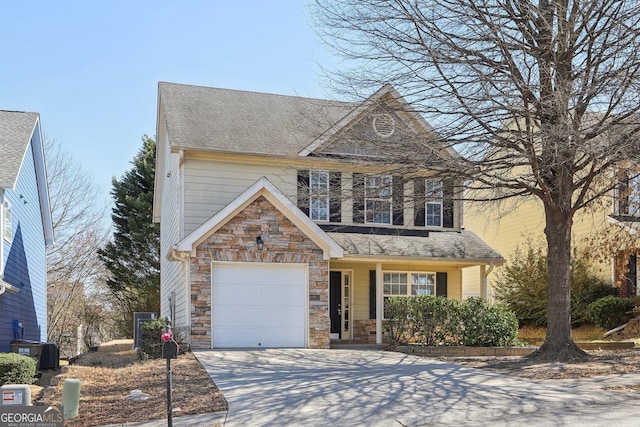 traditional-style home with a shingled roof, an attached garage, central AC unit, stone siding, and driveway