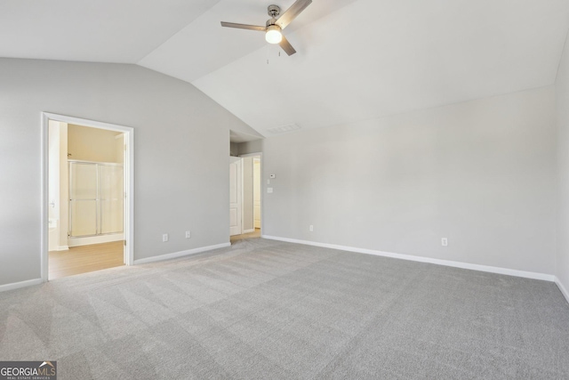 unfurnished bedroom with baseboards, connected bathroom, lofted ceiling, ceiling fan, and carpet flooring