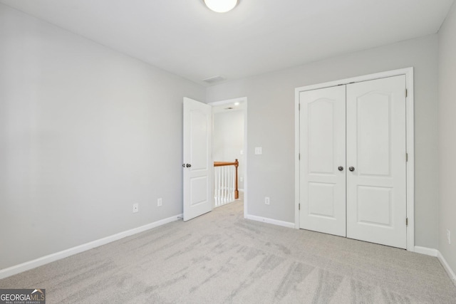 unfurnished bedroom with carpet floors, a closet, visible vents, and baseboards