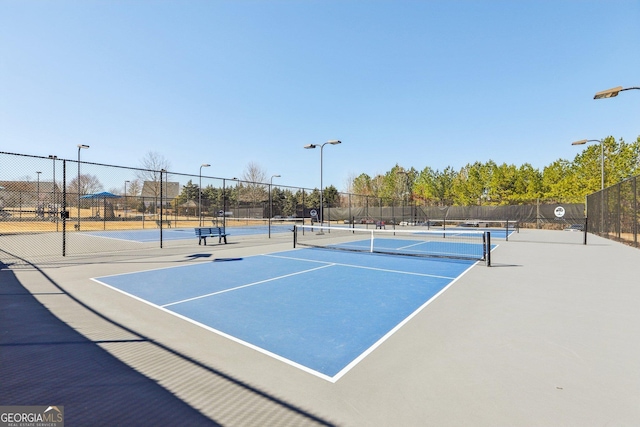 view of tennis court featuring fence