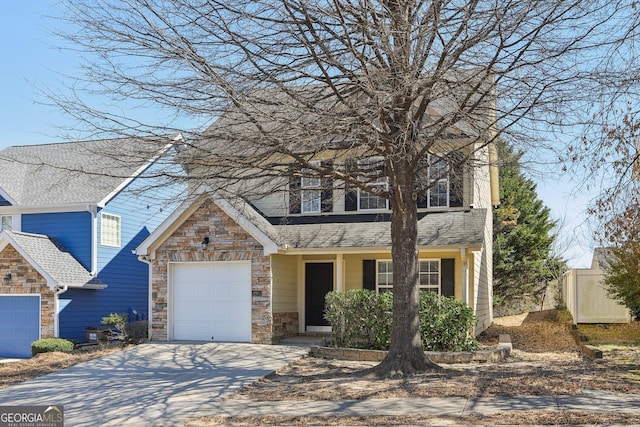 traditional-style house with a garage, driveway, a shingled roof, and stone siding