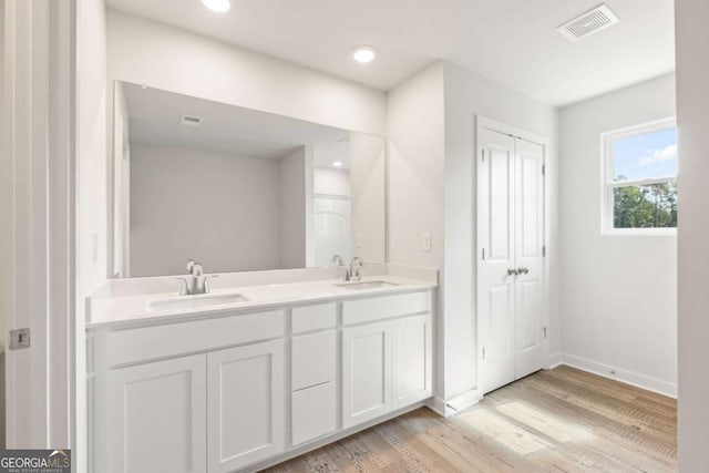 full bath featuring visible vents, a sink, and wood finished floors