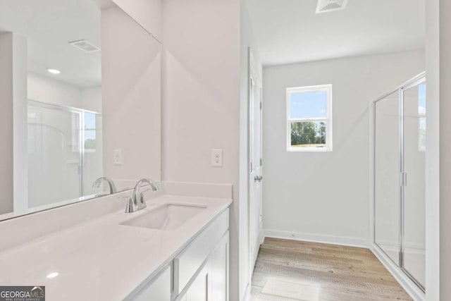 full bathroom with visible vents, a stall shower, wood finished floors, and vanity