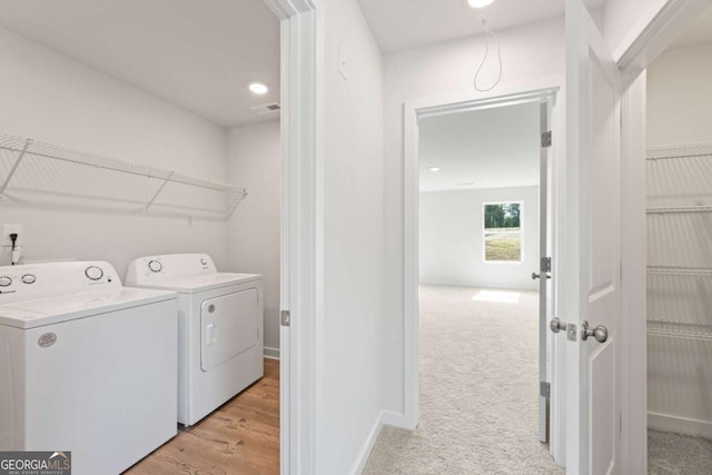 clothes washing area with visible vents, light carpet, laundry area, independent washer and dryer, and baseboards